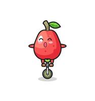 el lindo personaje de la manzana de agua monta una bicicleta de circo vector