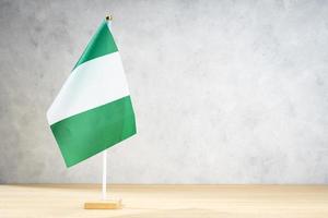 Bandera de mesa de Nigeria en la pared con textura blanca. copia espacio foto