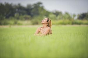 mujer joven sentada sentirse bien en el campo de hierba. foto