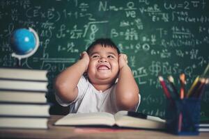 worried boy In classroom with hands on head photo