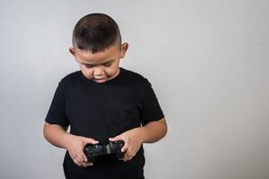 Happy boy play game computer with a controller in studio photo