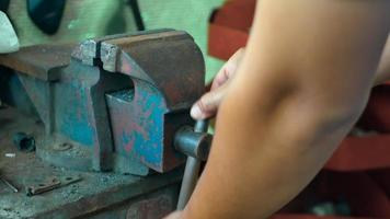 Man hold an old bench vise. He rotates handle of grip vice. video