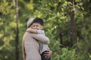 Portrait of mother and son happy cuddle together in the park. photo