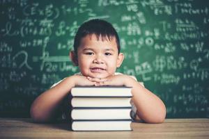 boy with books sitting in the classroom photo