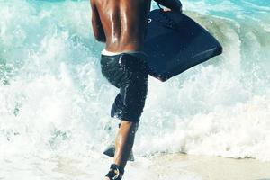 hombre caminando hacia el mar para surfear foto