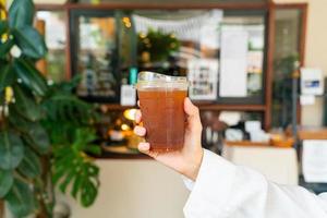 hand holding iced americano coffee glass photo