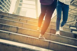 Close up legs of two traveling people walking on stepping up stair photo