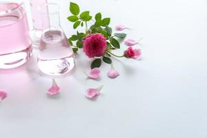 Tratamientos de spa rosa sobre mesa de madera blanca