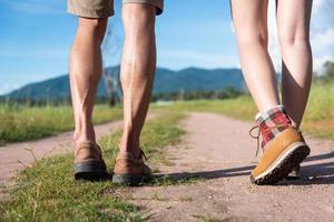 Close up of lower legs of two travelers walking along path in nature