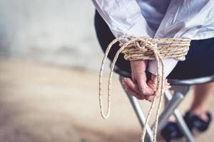 Close up of woman hand with tie rope. Hostage and ransom concept photo