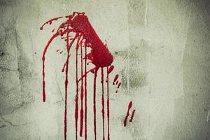 Salpicaduras de sangre roja en la pared de la casa abandonada foto