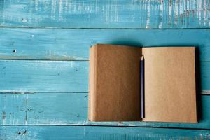 Top view of blank open notebook on blue wooden background photo