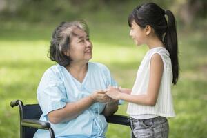 abuela anciana en silla de ruedas con su nieta en el hospital foto