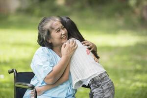 abuela anciana en silla de ruedas con su nieta en el hospital foto