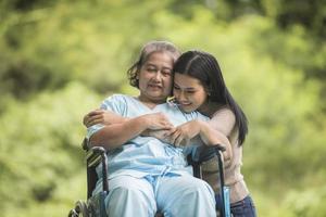 Granddaughter talking with her grandmother sitting on wheelchair photo