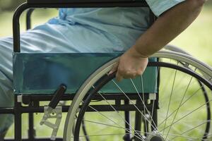 Close up Lonely elderly woman sitting on wheelchair at garden photo