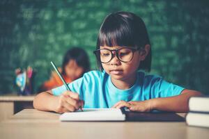 girl with crayon drawing at lesson in the classroom photo