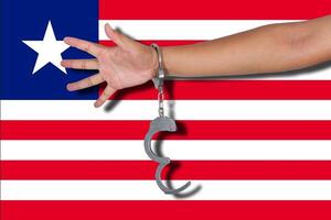 handcuffs with hand on Liberia flag photo