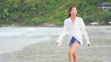 mulher asiática curtindo uma bela praia no oceano