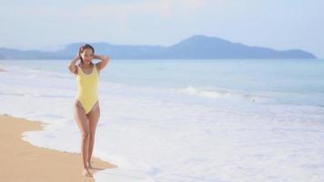 mulher asiática curtindo uma bela praia no oceano video