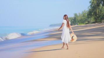 Asian woman enjoys beautiful ocean beach video