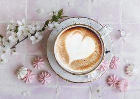 taza con café y pequeños merengues