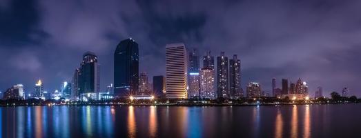 Big city in the night life with reflection of water wave photo