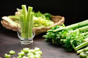 Bunch of fresh celery stalk on wooden table with leaves photo