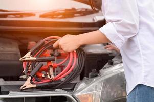 Primer plano de una mujer mano sujetando el cable de la batería de alambre de cobre foto