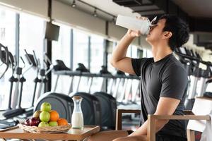 Handsome man drinking protein shake milk and many kind of fruits photo