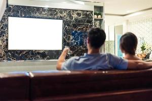 Parejas asiáticas viendo televisión con pantalla en blanco en blanco foto