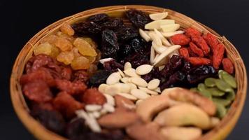 Various types of whole grains and dried fruits on a bamboo tray video