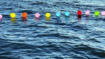 balões coloridos na água do mar
