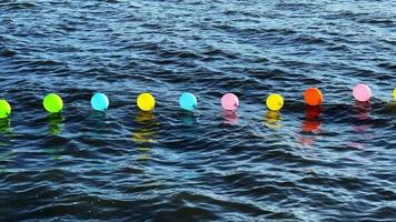 balões coloridos na água do mar