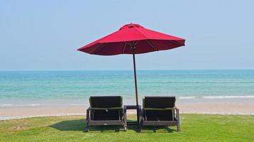 Beautiful tropical sea beach with umbrella chairs and a blue sky video