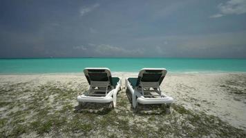 Beautiful tropical sea beach with umbrella chairs and a blue sky video