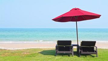 wunderschöner tropischer Meeresstrand mit Sonnenschirmstühlen und blauem Himmel video