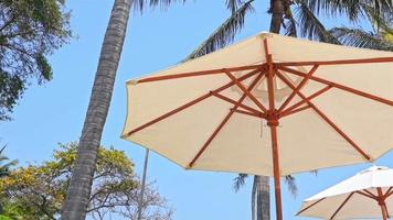 Beautiful tropical sea beach with umbrella chairs and a blue sky