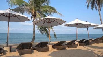 Beautiful tropical sea beach with umbrella chairs and a blue sky video