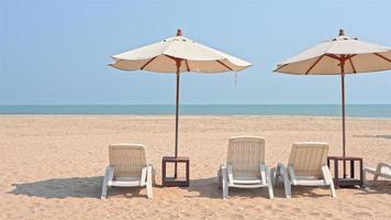 wunderschöner tropischer Meeresstrand mit Sonnenschirmstühlen und blauem Himmel video