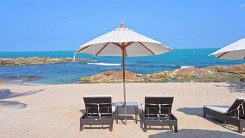 wunderschöner tropischer Meeresstrand mit Sonnenschirmstühlen und blauem Himmel video