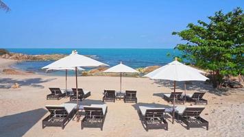 belle plage de la mer tropicale avec des chaises parapluie et un ciel bleu video