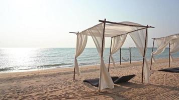 wunderschöner tropischer Meeresstrand mit Sonnenschirmstühlen und blauem Himmel video