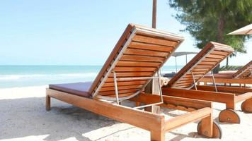 belle plage de la mer tropicale avec des chaises parapluie et un ciel bleu video