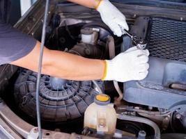 Mechanic holding a block wrench handle while fixing a car. photo