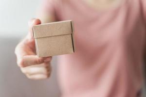 Woman hands holding a small gift box. Small present box in woman hand photo