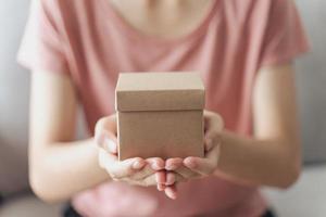 Woman hands holding a small gift box. Small present box in woman hand photo