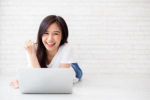 joven asiática emocionada y contenta de éxito con la computadora portátil. foto