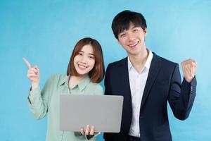Playful business couple image isolated on blue background photo