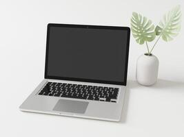 The laptop is placed on the floor with a vase and leaves. photo